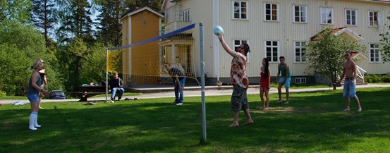 Några deltagare spelar volleyboll utanför skolan
