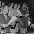 Sjungande personer med sångnoter i händerna.