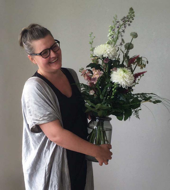 Konstnären Lina Sofia Lundin vid stipendieutdelningen, hon står med en bukett blommor i famnen.