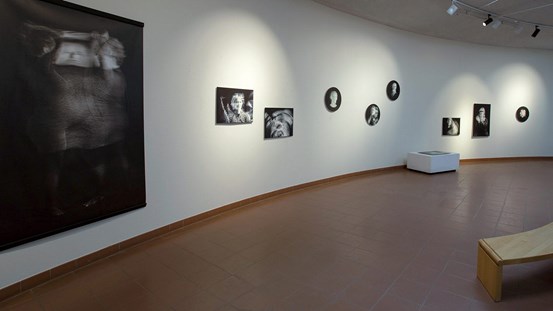 Utställningsvy från konsthallen i Ånge, med 10 svartvita fotografier i olika format och former. Fyra fotografier är runda. Sex fotografier är kvadratiska, varav ett ligger på ett podium.