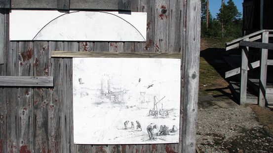 Kolteckningar monterade på en grånande biljettkiosk visar en framtidsversion där skogsråvaran är förbrukad och vilda fåglar bosätter sig bland tomma industriella ruiner.
