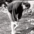 Barbent man som lägger om ett bandage med cyklar i bakgrunden.