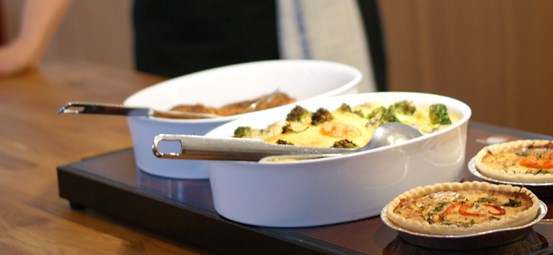 Två serveringsfat med olika maträtter och två pajer.