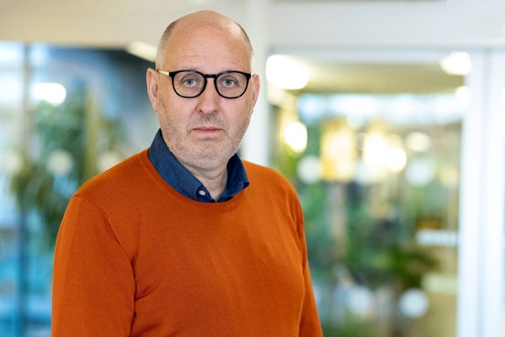 man i orange tröja och svartbågade glasögon, Lars Halén, ekonomidirektör