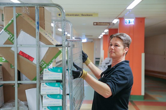 Lotta Nordlund i färd med att ta bort grinden på en vagn lastade med varor levererade till sjukhuset i Sollefteå.