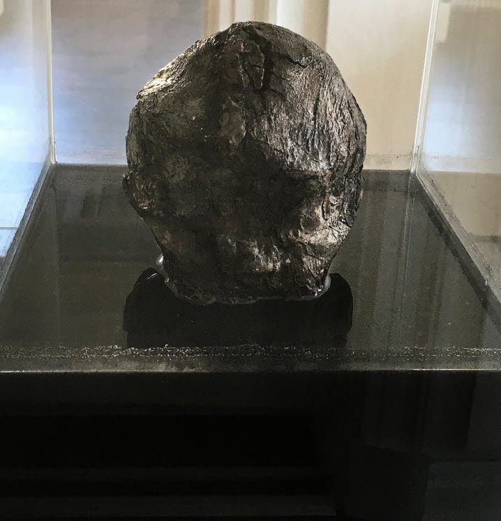 Verket ”Melas chole 3” (Svart galla 3): den beskurna bilden visar en glasbehållare där skulpturen av ett svärtat huvud sänkts ner i svart vätska.