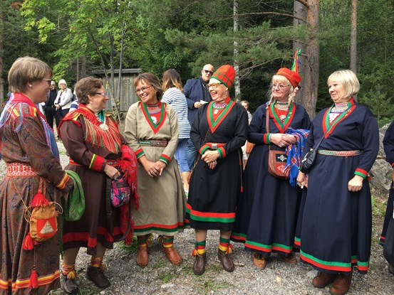 Några kvinnor i traditionella samiska dräkter står samlade tillsammans. 