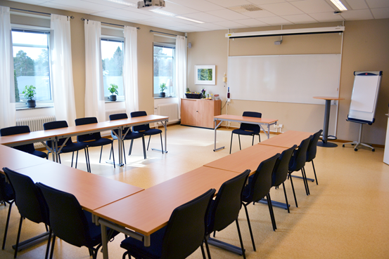 Stolar och bord i ett ljust konferensrum.