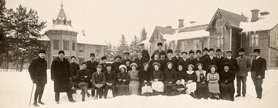 En svartvit gruppbild tagen framför skolbyggnader