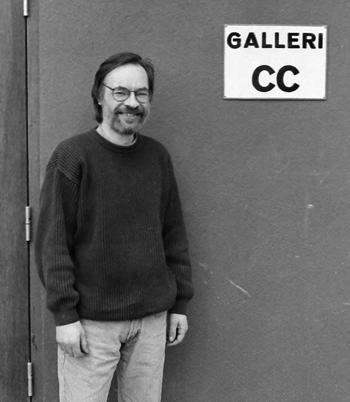 Svartvitt fotografi av Christer Carlstedt vid dörren till sitt Galleri CC i Gullänget 1994.