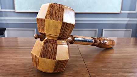 Ordförandeklubba ligger på ett bord. 