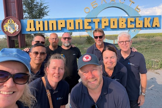 Gruppfoto av Region Västernorrlands delegation framför ortsskylten för Dnipropetrovska oblast i Ukraina.