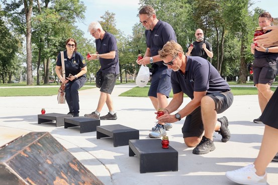 Deltagare från Region Västernorrland tänder minnesljus vid ett monument under ett besök i Ukraina