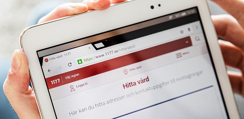 Händer som håller en surfplatta med 1177.se Hitta vård.