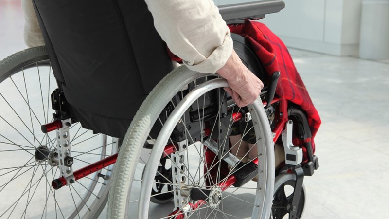 Äldre person sitter i rullstol