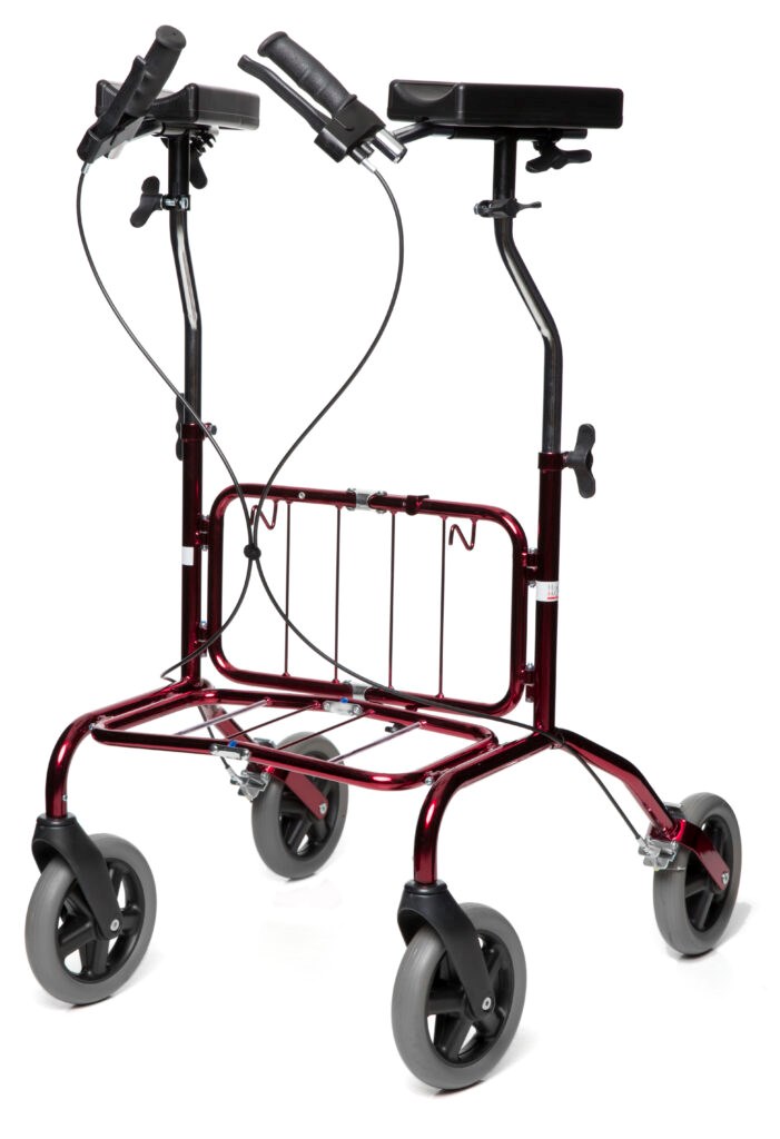 Mörkröd fyrhjulig rollator, små hjul. Höga armstöd med skålade underarmsstöd. Handbromsar. Krokar och underrede för korg. 