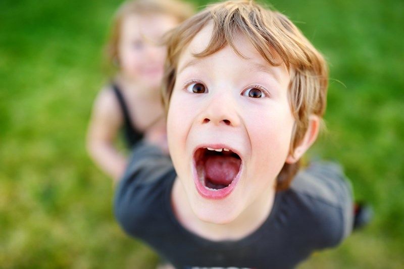glad pojke gapar mot fotografen