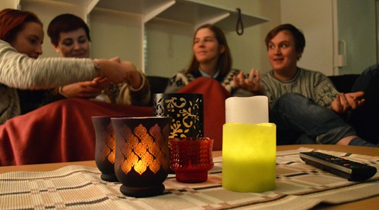 Några elever sitter i en soffa framför ett bord med ljuslyktor