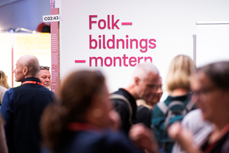 Ett myller av människor framför skylt med texten Folkbildnings-montern.