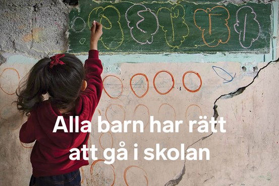 En flicka står med ryggen mot kameran och skriver med en krita på en vägg med sprickor i samt texten Alla barn har rätt att gå i skolan.