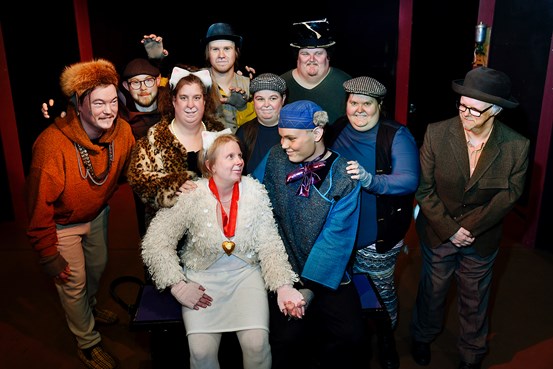 En gruppbild med flera personer som har klätt ut sig i kattdräkter i en teatersalong.