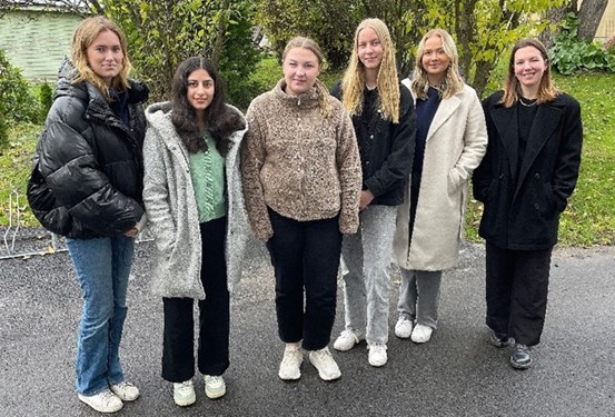 Sex unga tandvårdslärlingar utomhus i en gruppbild.
