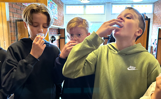 Eleverna Malte Tallqvist, Birger Bäckman och Noah Linnér sköljer med fluoridlösning.