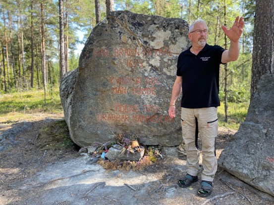 Guide står framför minnessten vid Häxberget