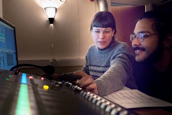 En tjej och en kille sitter vid ett mixterbord