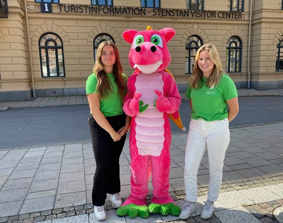 Tre ungdomar står framför Stenstan Visitor Center, en av ungdomarna har på sig en drakdräkt.