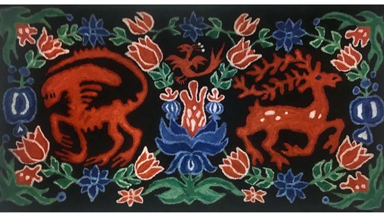 Färgstark tovad filt med folkloristiskt stiliserade motiv mot svart bakgrund. Två röda, fyrbenta varelser går ut från centrum av bilden. Djuren omges av röda och blå kurbitsliknande blommor med gröna blad.